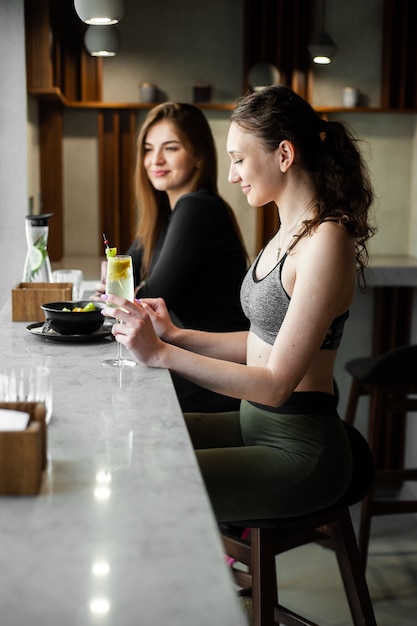 Vrouwen chillen en drinken gezond drinken na het sporten