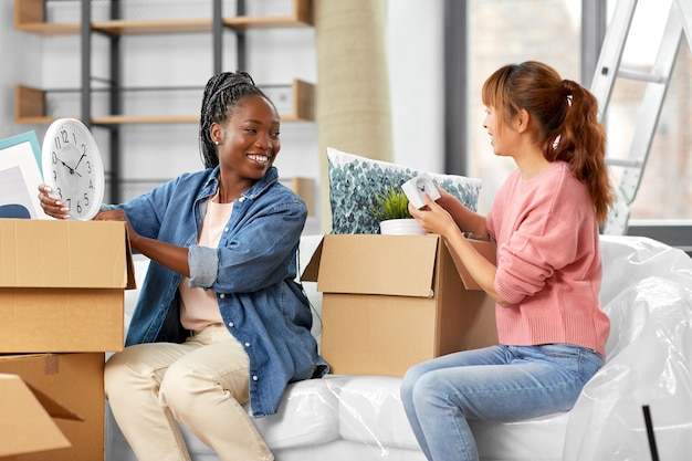 vrouwen die dozen uitpakken en naar een nieuw huis verhuizen