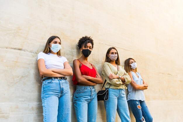 Vrouwen die een gezichtsmasker dragen om de verspreiding van het coronavirus te voorkomen - portret van jonge millennial vrouwen