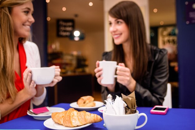 Vrouwen die koffie en snacks hebben bij een koffiewinkel