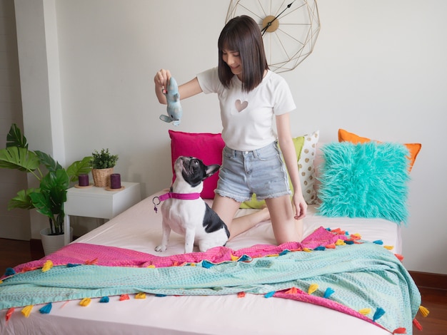 Vrouwen die met honden op het bed spelen