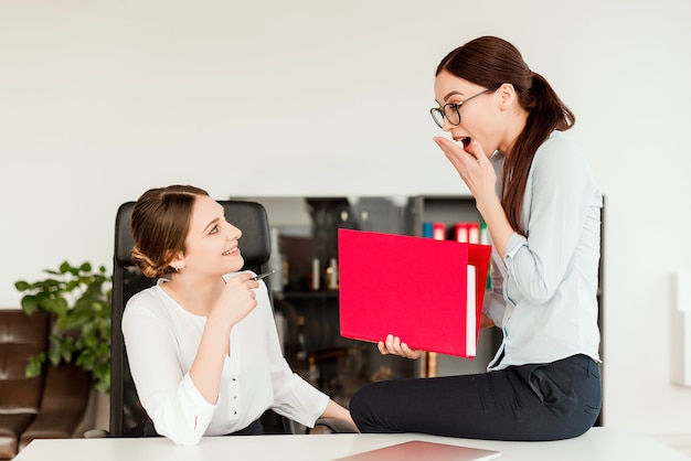 Vrouwen die nieuws delen op kantoor op de werkplek