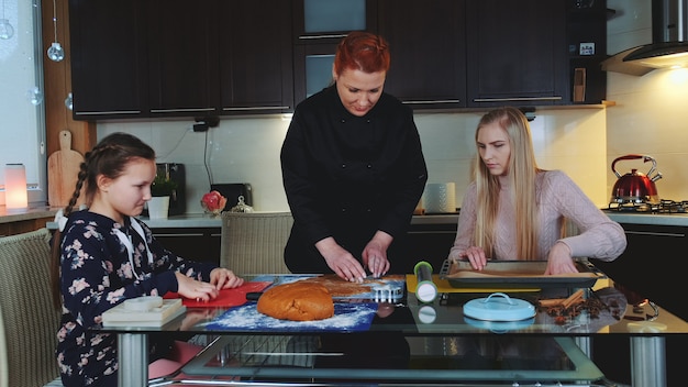 Vrouwen die peperkoekkoekjes thuis in de keuken bakken