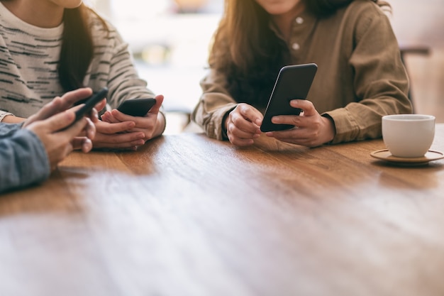 Vrouwen die samen mobiele telefoons gebruiken en bekijken