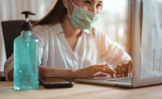 Vrouwen die vanuit huis werken en maskerbescherming dragen, wachten tot de epidemische situatie snel thuis verbetert. Coronavirus, covid-19, Thuiswerken (WFH), Sociale afstand, Quarantaine, Infectieconcept voorkomen.