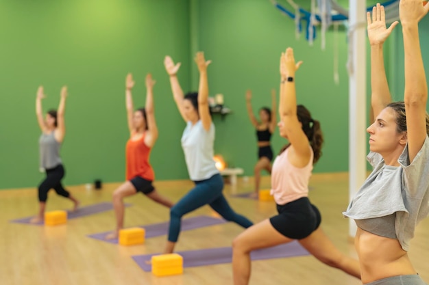 Vrouwen die yoga beoefenen in een yogacentrum in Ashta Chandrasana pose