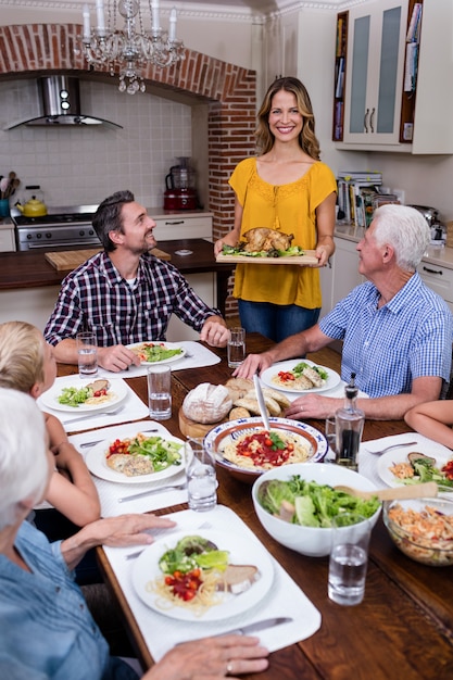 Foto vrouwen dienend voedsel aan haar familie in de keuken