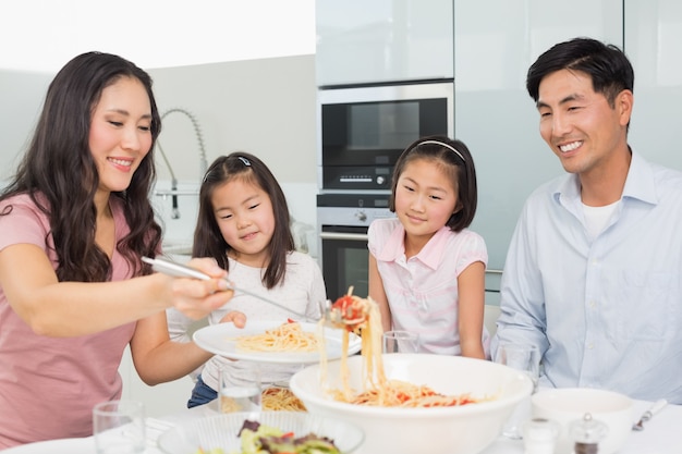 Vrouwen dienend voedsel voor de familie in keuken