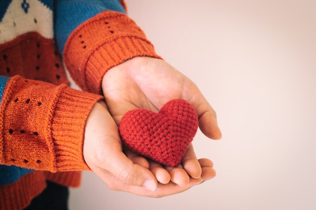 Vrouwen dragen gebreide overhemdshand met rood hart.