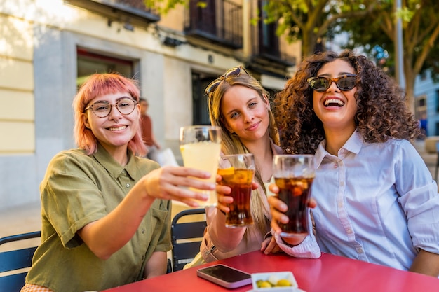 Vrouwen drinken voor de camera op het terras van een bar.