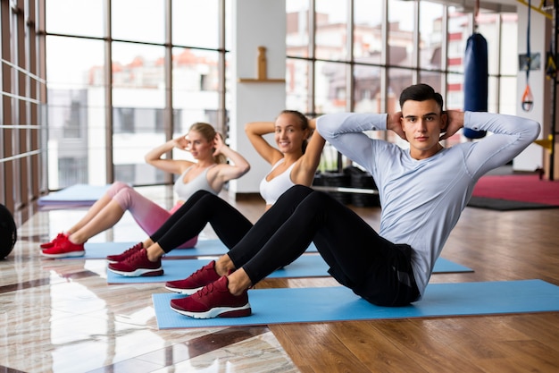 Vrouwen en man die bij gymnastiek uitoefenen