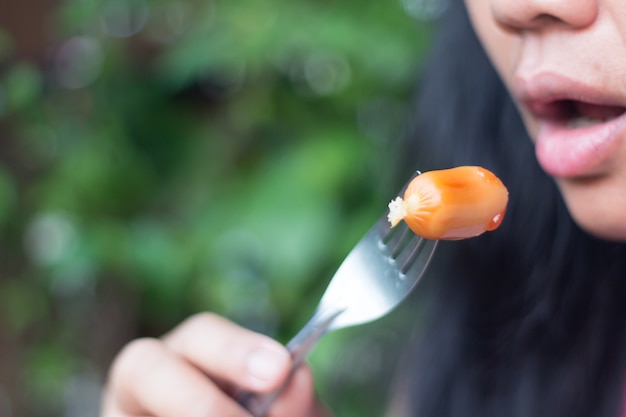 Foto vrouwen eten worstjes.