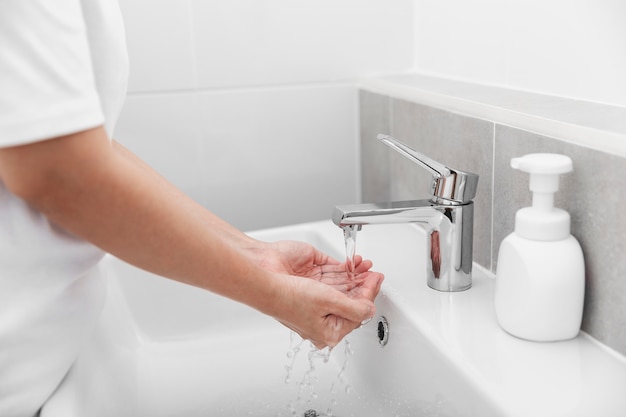 Vrouwen gebruiken zeep en handen wassen onder de waterkraan voor het voorkomen van coronavirus.