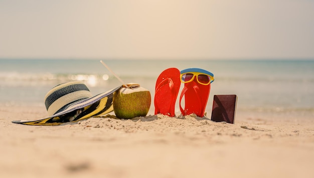 Foto vrouwen gele zonnebril en rode flipflopshat strand en kokosnoot op sandyreizen over zee strandvakantietropisch zandstrand zomer reizen vakantie en zomervakantie concepten