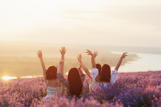 vrouwen genieten van het moment dat ze samen de zonsondergang in het lavendelveld ontmoeten