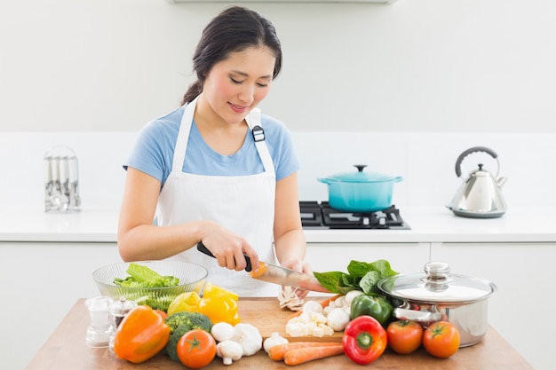 Vrouwen hakkende groenten in keuken