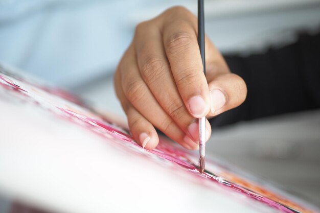 Vrouwen hand met penseel met verf