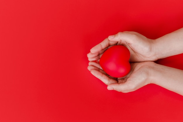 Vrouwen handen met rood hart op rood