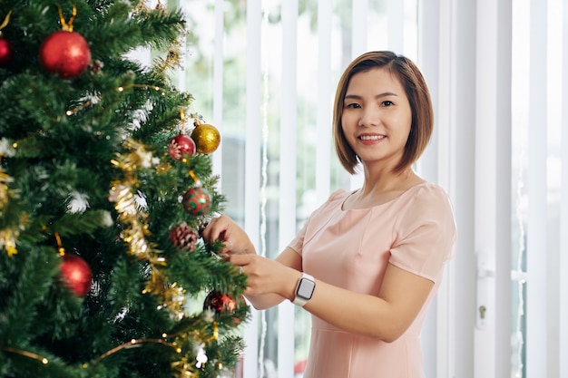 Vrouwen hangende snuisterijen op boom