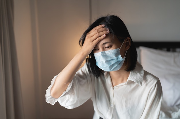 Vrouwen hebben een zieke en dragen een chirurgisch masker in de slaapkamer