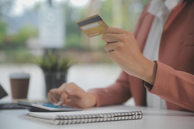 Vrouwen houden creditcard vast en gebruiken smartphones thuis Online winkelen internetbankieren winkel online betaling zakgeld e-commerce betaling in de winkel creditcard concept