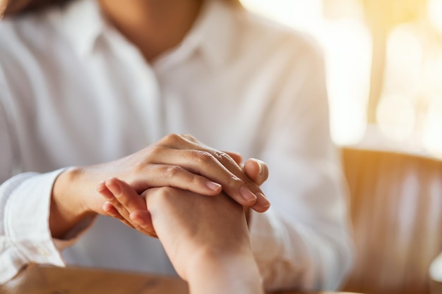 Vrouwen houden elkaars hand vast voor troost en medeleven