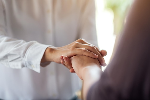 Vrouwen houden elkaars hand vast voor troost en medeleven