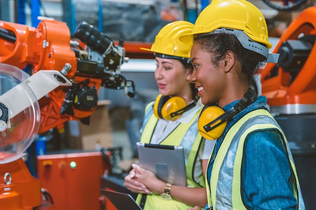 Vrouwen ingenieur arbeiders werkend team samen helpen op het werk in moderne geavanceerde machinefabriek