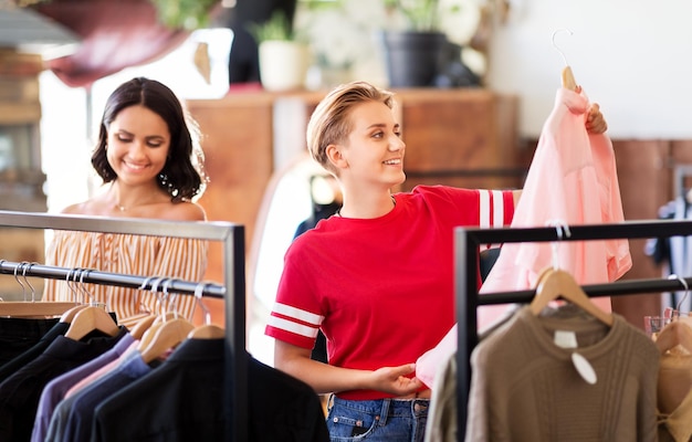 Vrouwen kiezen kleren in een vintage kledingwinkel.