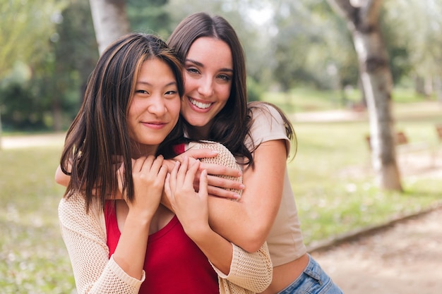 Vrouwen kijken camera omarmen en glimlachen