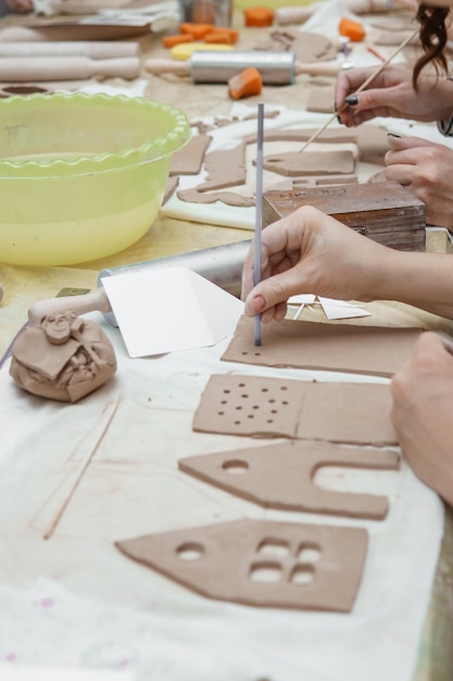 Foto vrouwen kneden met hun handen klei en tekenen elementen van de productie van keramische producten