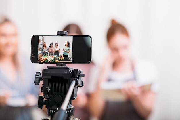 Vrouwen koken hobby. Culinaire blog. Video-tutorial schieten. Vrouwtjes op het smartphonescherm.