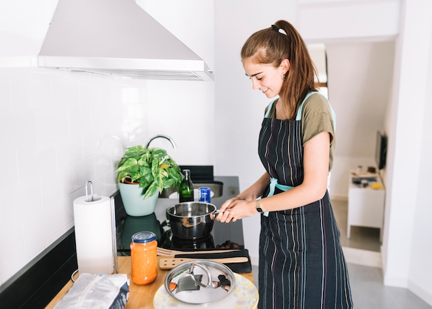 Foto vrouwen kokend water in de steelpan over elektrisch fornuis