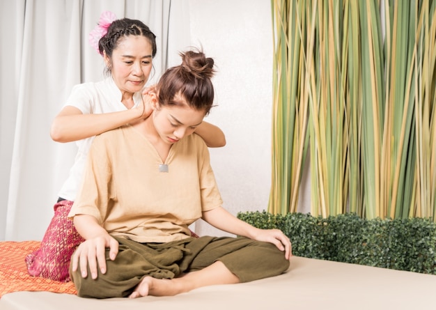 Vrouwen krijgen schouder- en nekmassage door Thai Therapist