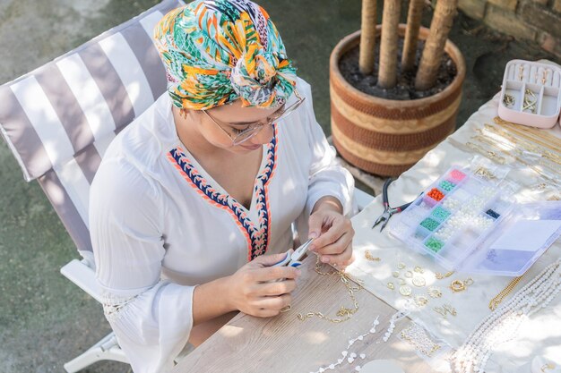 Vrouwen maken kettingen op rustieke houten tafel