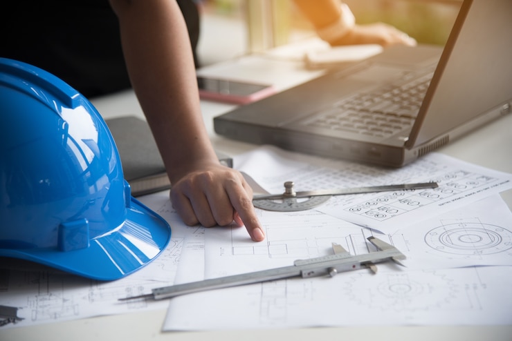 Foto vrouwen mechanische ingenieur die aan ingenieurswerkplaats werken.
