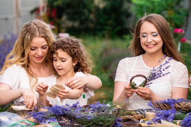 Vrouwen met dochters die buiten lavendelboeketten maken