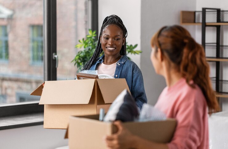Foto vrouwen met dozen verhuizen naar een nieuw huis.