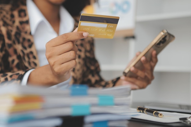 Vrouwen met een creditcard en die thuis een smartphone gebruikenOnline winkelen internetbanking online winkelen online betalen geld uitgeven e-commerce betalen in de winkel creditcardconcept