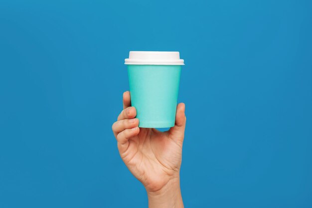 Vrouwen met een turquoise eco-papierbeker met wit deksel met thee koffie Mockup met kopieerruimte