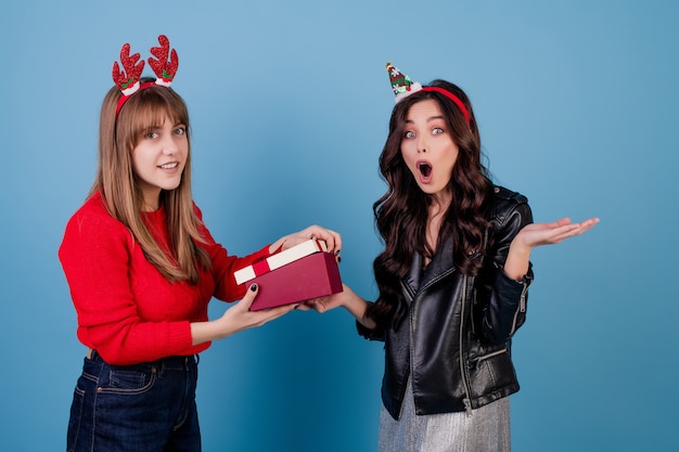 Vrouwen met geschenkdoos met lint dragen grappige kerst hoepels