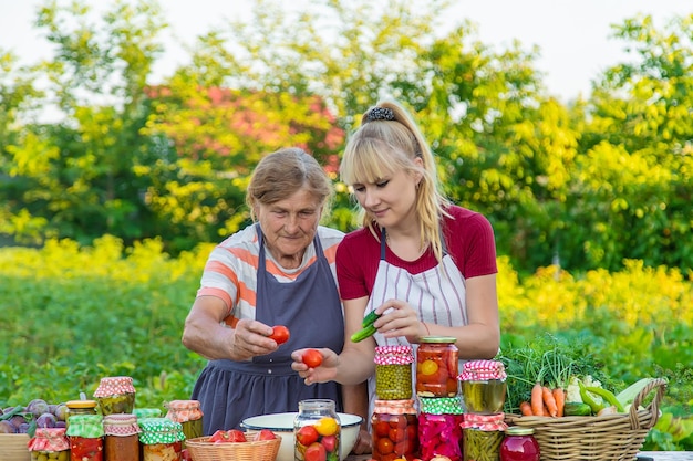 Vrouwen met pot geconserveerde groenten voor de winter moeder en dochter Selectieve focus