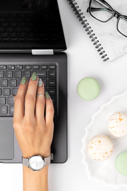 Vrouwen met verzorgde handen met groene lente zomer nagel ontwerp type op toetsenbord