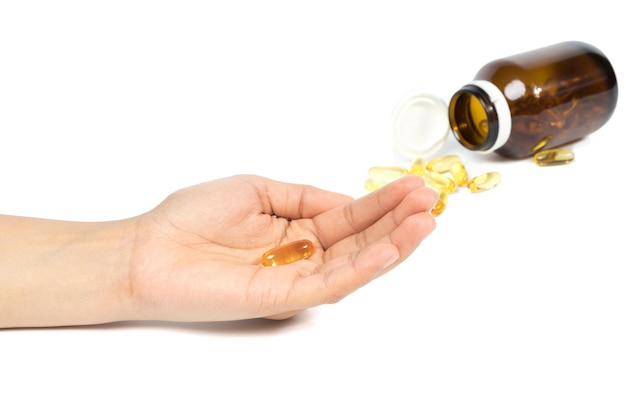 Vrouwen met visolie-capsules met omega-3 en vitamine D in de hand, gezond dieetconcept geïsoleerd op een witte achtergrond