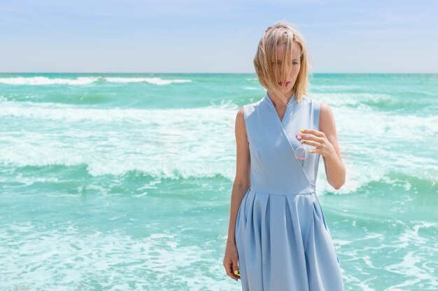 Vrouwen met zandloper en zee-achtergrondconcept reizen in de zomer