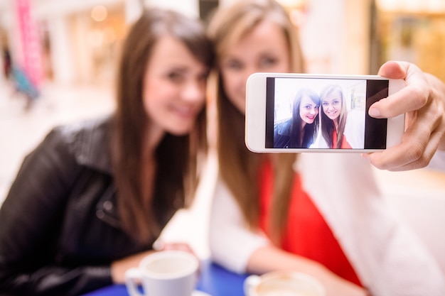 Vrouwen nemen een selfie terwijl ze koffie drinken