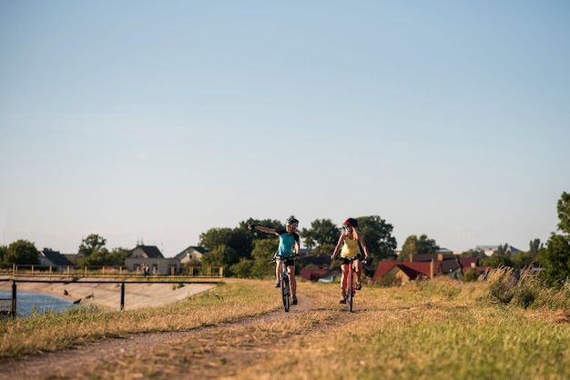 Vrouwen op de fiets langs de oever van het meer buiten in het park