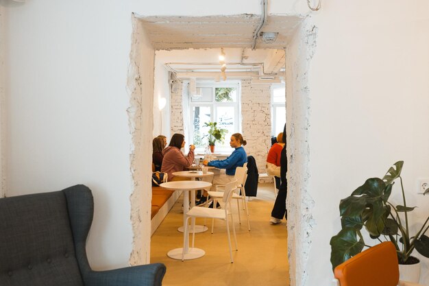 Vrouwen praten aan een kleine ronde tafel in een gezellig café