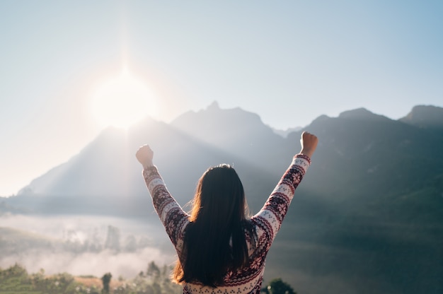 Foto vrouwen reizen natuur in de bergen, vrouw kijkt naar de zonsopgang en verschijnt handen