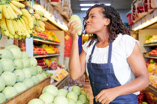 Vrouwen ruikende mango in opslag